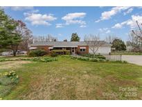 Charming brick home with a metal roof, well-maintained landscaping, and an accessible ramp at 230 Dunham Ave, Salisbury, NC 28146