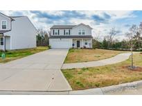 Two-story home featuring neutral siding, attached garage, long driveway, and well-maintained lawn at 3077 Light Ridge Sw Ct, Concord, NC 28027