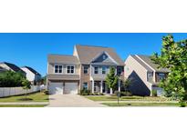 Charming two-story home with brick and siding, featuring a two-car garage and well-manicured lawn at 4892 Horseback Ln, Harrisburg, NC 28075