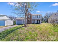 Charming two-story home with a well-maintained lawn and attached garage at 7619 Woodknoll Dr, Charlotte, NC 28217