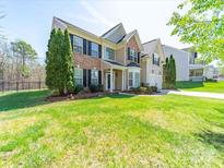 Charming two-story home with brick and siding exterior, complemented by a well-manicured lawn and landscaped garden at 7719 Whisperingwood Dr, Harrisburg, NC 28075