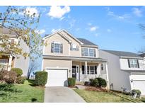 Charming two-story home with a well-maintained lawn, attached garage, and covered front porch at 11331 Breezehill Ln, Charlotte, NC 28262