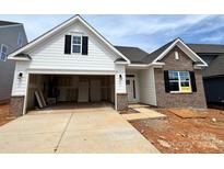 New construction home with brick and siding exterior, open garage, and partially finished landscaping at 1453 Ardmore Dr # 240, Sherrills Ford, NC 28673