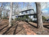 Charming home with a brick path leading to the covered entrance, surrounded by mature trees at 1793 Fairway Dr, Newton, NC 28658