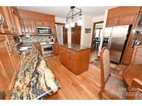 Spacious kitchen featuring wooden cabinets, stainless steel appliances, and granite countertops, perfect for cooking and entertaining at 1793 Fairway Dr, Newton, NC 28658