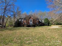 Charming two-story brick home with a well-manicured lawn and mature trees providing shade and privacy at 1933 Tara Trl, Lancaster, SC 29720