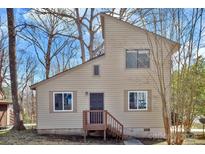 Two-story home featuring neutral siding, a simple front door, and a small entry porch and is nestled in a wooded setting at 2406 Brook Canyon Dr, Charlotte, NC 28212