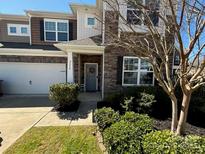 Charming townhome with a well-manicured lawn, a two car garage, and appealing stone and siding accents at 2640 Southern Trace Dr, Waxhaw, NC 28173