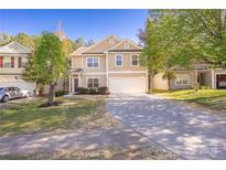 Two-story home with a well-manicured lawn, a two-car garage, and a long concrete driveway at 4528 Potters Glen Rd, Charlotte, NC 28269