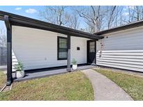 Inviting front entrance with manicured landscaping, a pathway, and a stylish black front door at 5501 Joyce Dr, Charlotte, NC 28215