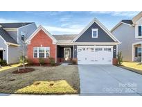 Charming single-story home with a brick accent, attached garage, and well-maintained lawn at 1032 Barnette Farm Ln, Monroe, NC 28110