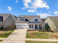 Charming two-story home featuring a three-car garage, covered porch and manicured lawn at 10547 Skipping Rock Nw Ln, Concord, NC 28027