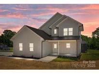 Stunning two-story home with a beautifully illuminated exterior at dusk at 106 Desert Sky Ct, Statesville, NC 28625