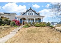 Charming blue two-story home with a welcoming front porch and landscaped front yard at 120 Keats Aly, Cramerton, NC 28032