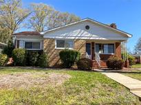 Charming single-story home featuring a brick facade, well-manicured bushes and a tidy front yard at 1400 Russell Ave, Charlotte, NC 28216