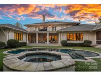Beautiful backyard featuring a pool, hot tub, and covered patio with stunning sunset views at 19117 Davidson Concord Rd, Davidson, NC 28036