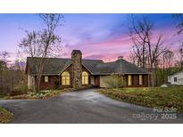Stunning brick home with stone chimney, manicured landscaping, and a circular driveway under a gorgeous dusk sky at 3772 Sandy Ford Rd, Hickory, NC 28602