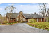 Charming brick home with a stone chimney, arched windows, and a well-maintained front yard at 3772 Sandy Ford Rd, Hickory, NC 28602
