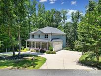 Two-story home with gray siding, stone accents, and a well-manicured lawn with mature trees at 463 Lake Wylie Rd, Belmont, NC 28012