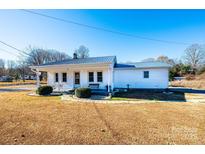 Charming single story home with inviting front porch, metal roof, and manicured landscaping at 129 38Th St, Hickory, NC 28601