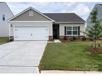 Charming one-story home with a well-manicured lawn, attached two-car garage, and traditional design elements at 3406 Saddlebred Dr, Gastonia, NC 28052