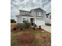 Charming two-story home with stone accents, landscaped yard, and a two-car garage at 346 Knotty Wood Dr # 71, Monroe, NC 28110
