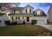 Charming two-story home with a welcoming front porch and well-maintained landscaping at 6019 Timbertop Ln, Charlotte, NC 28215