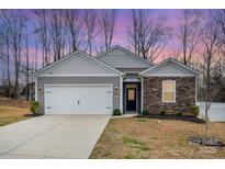 Charming single-Gathering home with stone accents, a two-car garage, and a well-manicured lawn at 10500 Bradstreet Commons Way, Charlotte, NC 28215