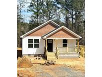 Charming single-story home with white siding, cedar shake accents, and a welcoming front porch, set on a wooded lot at 1228 Belmont Circle Rd, Lancaster, SC 29720