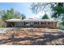 Charming brick home featuring a metal roof, level yard, and carport at 126 Regal Cir # 2122, Mooresville, NC 28115