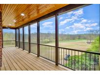 Enjoy outdoor views from this screened porch, complete with wood floors and railing at 1316 Valhalla Dr, Denver, NC 28037