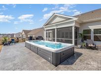 Backyard view featuring a hot tub, screened in porch, patio, and manicured backyard at 1512 Brooksland Pl, Waxhaw, NC 28173
