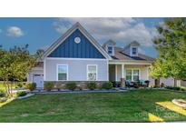 Charming home featuring blue and gray tones, stone accents, and a well-manicured lawn, creating excellent curb appeal at 1512 Brooksland Pl, Waxhaw, NC 28173