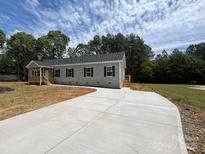 Charming single-story home with light gray siding, black shutters, and a newly constructed concrete driveway at 2070 Travis Rd, Conover, NC 28613