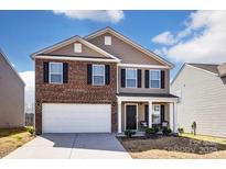 Two-story home boasts mixed brick and siding exterior and an attached two-car garage at 2135 Eastway Dr, Dallas, NC 28034