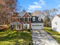 Charming two-story brick home with a well-manicured lawn and attached two-car garage at 2604 Lamplighter Dr, Kannapolis, NC 28081