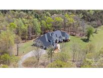 Aerial view of a large home with a well-manicured lawn surrounded by trees at 447 Willow Pond Ln, Hiddenite, NC 28636