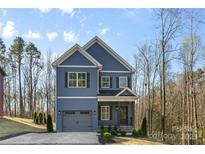 Beautiful two-story home with blue siding, gray accents, two-car garage, and a well-maintained landscaped yard at 615 W Stanly W St, Stanfield, NC 28163