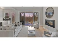 Bright living room with fireplace, neutral decor, and sliding doors to the outdoor patio at 1132 Meander Ln, Waxhaw, NC 28173