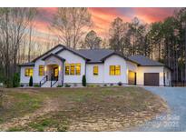 Sprawling single-story home with neutral stucco, black trim, and a two-car garage at 1208 Union Rd, Matthews, NC 28104