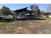 Exterior view of charming property with awning, porch, and gravel driveway with a boat on the side at 143 Sunshine Trl # A32, Mount Gilead, NC 27306