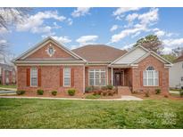 Charming brick home featuring a well-manicured lawn and inviting front entrance at 1730 Sanridge Wind Ln, Charlotte, NC 28262