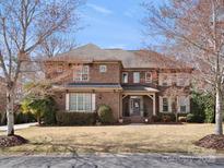 Beautiful brick home featuring mature trees, a manicured lawn and charming architectural details at 604 Wisteria Walk Way, Fort Mill, SC 29715