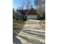 Charming brick home with a two-car garage and a long driveway at 7144 Hunters Bluff Dr, Denver, NC 28037