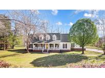 Charming two-story home with a welcoming front porch, well-manicured lawn, and mature trees at 737 Sanside Dr, York, SC 29745