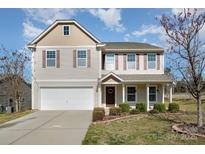 Charming two-story home with vinyl siding, shutters, and a well-maintained front yard at 887 Pointe Andrews Dr, Concord, NC 28025