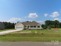 Charming single-story home featuring a welcoming front porch, attached garage, and a well-manicured lawn at 122 Mason Tanner Ct # 5, Rock Hill, SC 29730