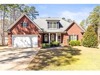 Charming brick home featuring a two-car garage, manicured lawn, and mature trees at 3334 Cloninger Rd, Dallas, NC 28034