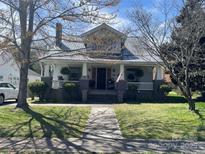 Charming home featuring a welcoming front porch, manicured lawn, and mature trees, offering classic curb appeal at 421 Mitchell Ave, Salisbury, NC 28144