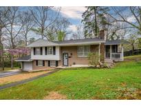 Charming home featuring a well-maintained lawn, brick facade, attached garage, and a screened-in porch at 107 Wedgewood Ne Cir, Concord, NC 28025